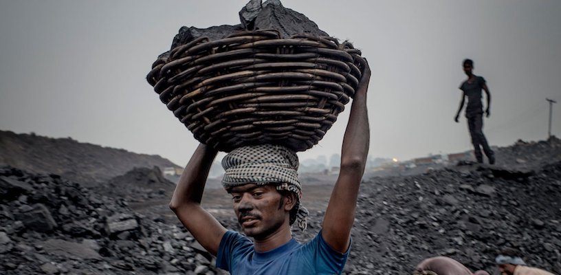 индийский рабочий переносит уголь 